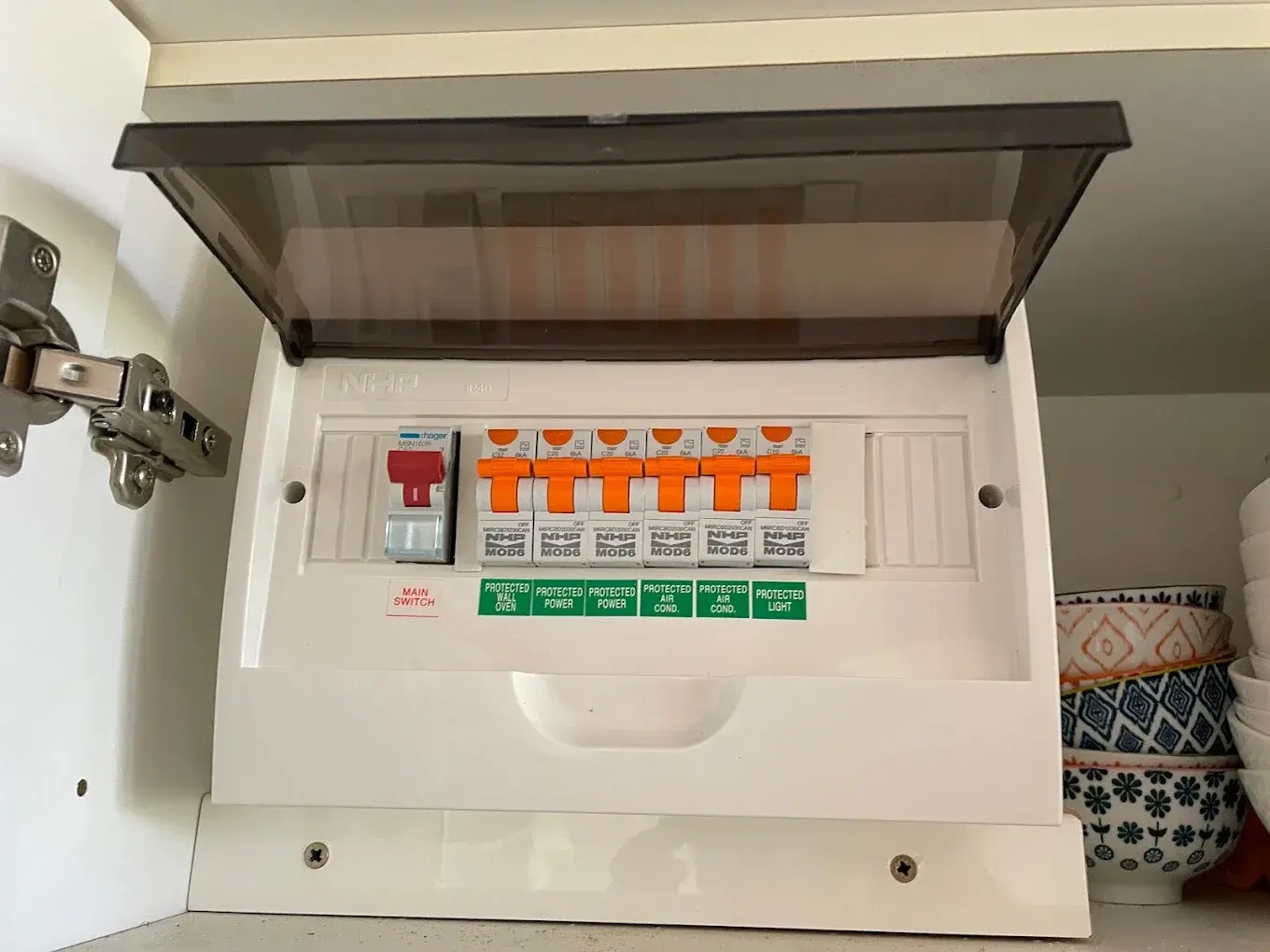 Electric circuit breaker panel with multiple switches and labels.