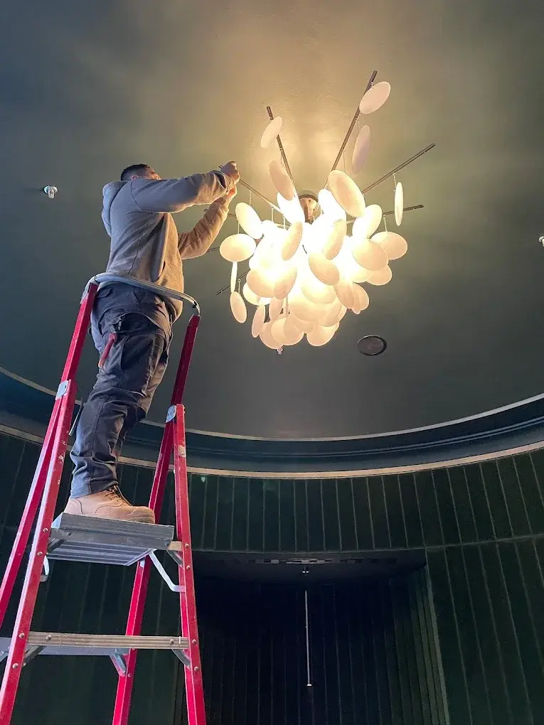 A Spartech electrician on a ladder carrying out an installation.