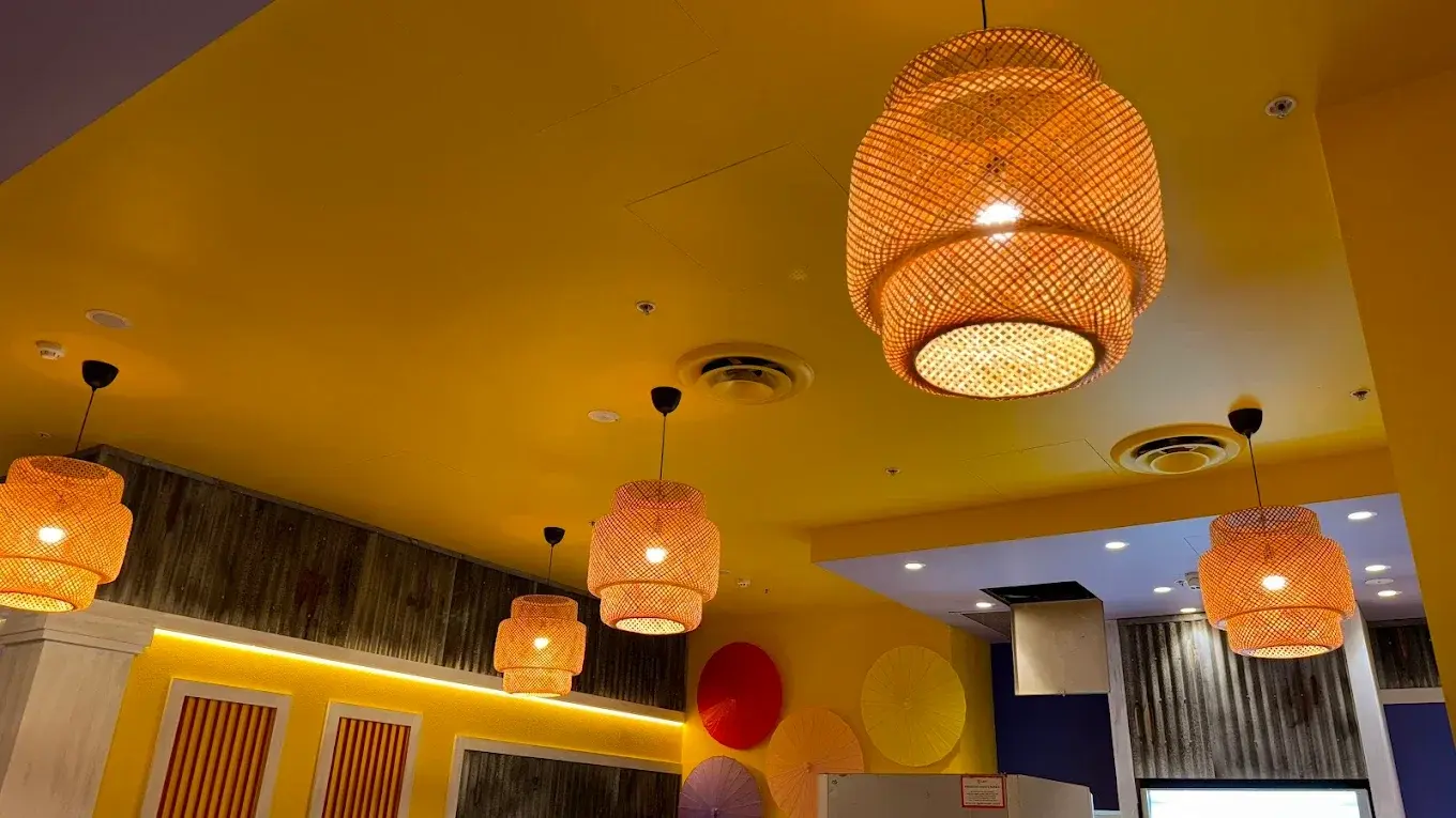 Interior of a room with hanging wicker lights and warm lighting.