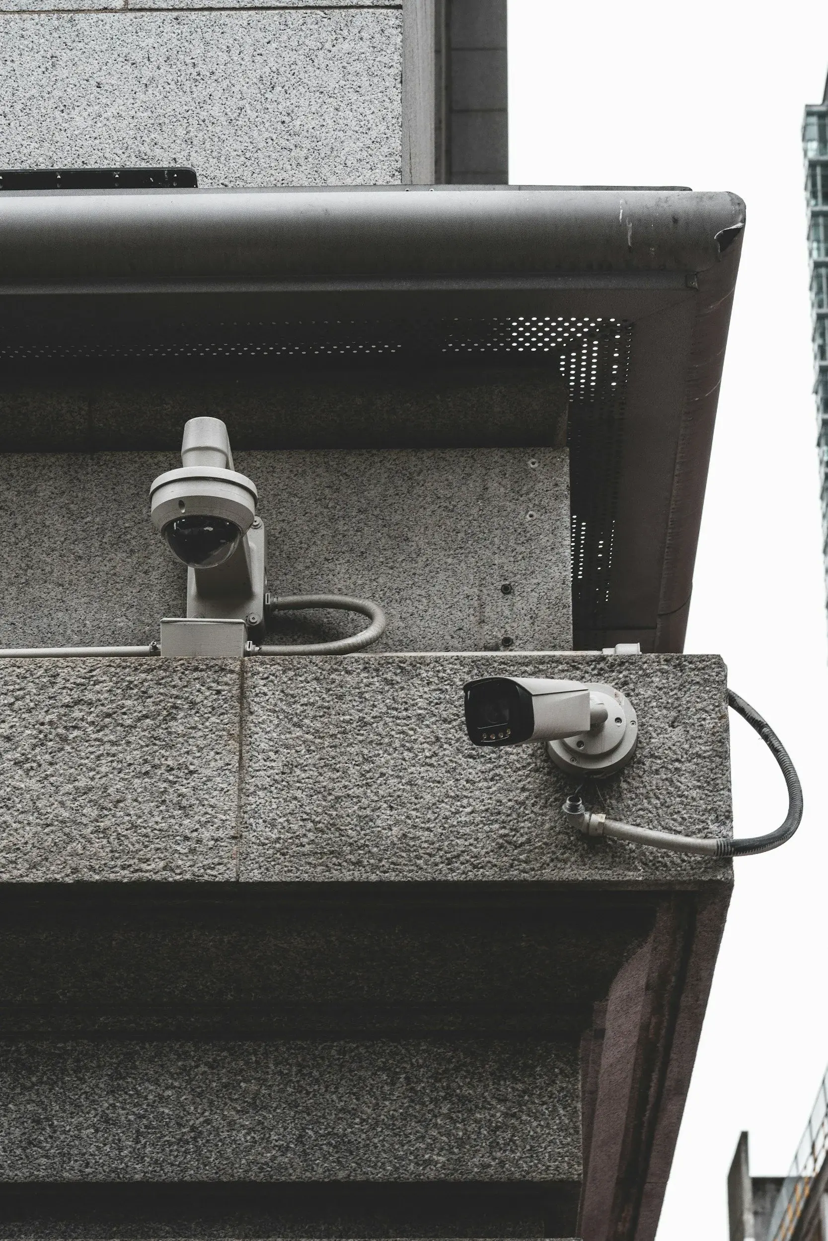 Two security cameras mounted on the corner of a building.